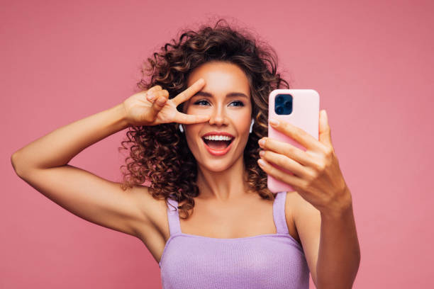 istock Woman in wireless earbuds making selfie 1294323413