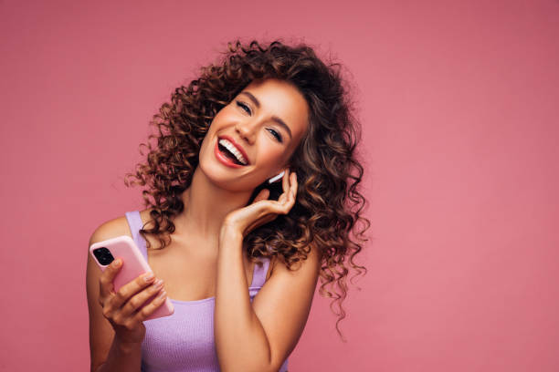 istock Woman in wireless earbuds holding smartphone 1294323455