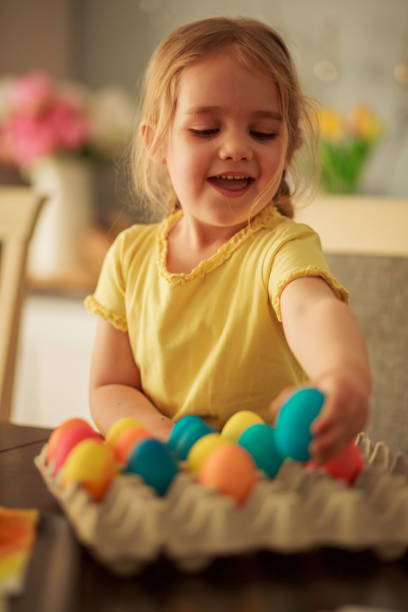 istock Little girl arranging Easter eggs into egg carton 1294325620