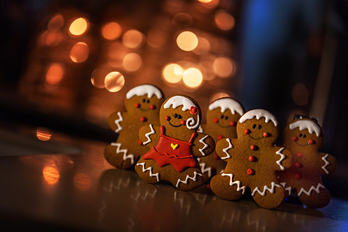 Christmas card made of gingerbread man, coffee, sweets and calendar on brown background. New Year and Christmas concept.