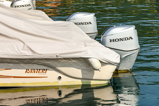 Lake Garda, Italy - September 2018: Speedboat with waterproof weather cover and twin outboard motors. The engines are manufactured by Honda.