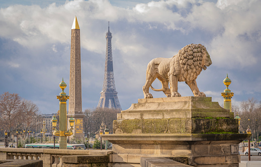 Paris,France - 12 30 2020: View of the Luxor Obelisk, the lion sculpture and the Eiffel tower from Place de la Concorde