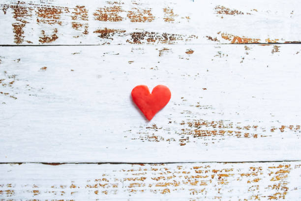 istock Plasticine red heart on white wood background. 1294328245