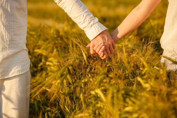 istock Couple holding hands while walking in a wheat plantation 1294328385