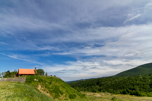 Different clouds in the blue sky and house of mountain in Turkey