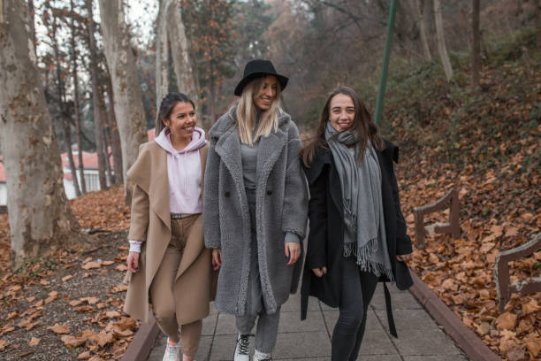 istock Three young smiling women having fun in park 1294330332