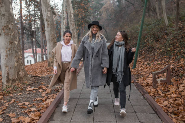 istock Three young women friends walking in park 1294330419
