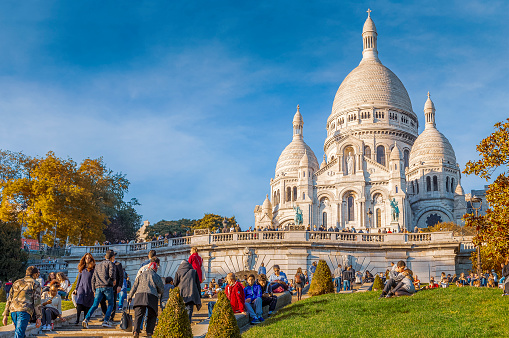 The stairs and lawns in front of the Sacre Coeur, Montmartre, Paris, attracts tourists and local alike, especially on sunny warm days.