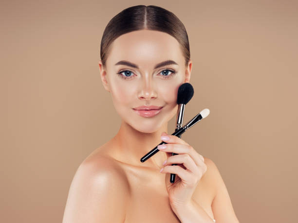 istock Beautiful young woman applying foundation powder 1294330658