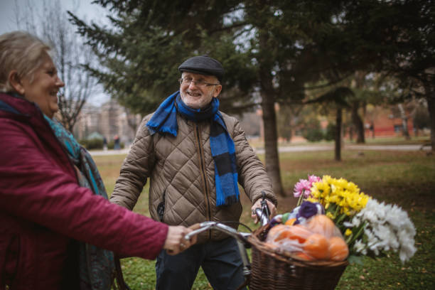 istock Active Senior Couple in Park walking with bicycle. 1294332721