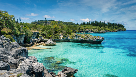 Pede Bay Lagoon on the south-west coast of Maré Island with beautiful natural rocky turquoise lagoon and coral reef under sunny blue summer sky. Pede Bay Bay - Tadine Bay, Mare Island, Loyalty Islands, New Caledonia, Pacific Ocean Islands.