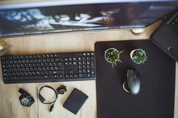 istock Top view, view of computer desk. Workspace. Wooden table top view 1294334027