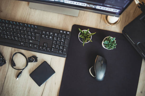 istock Top view, view of computer desk. Workspace. Wooden table top view 1294334029