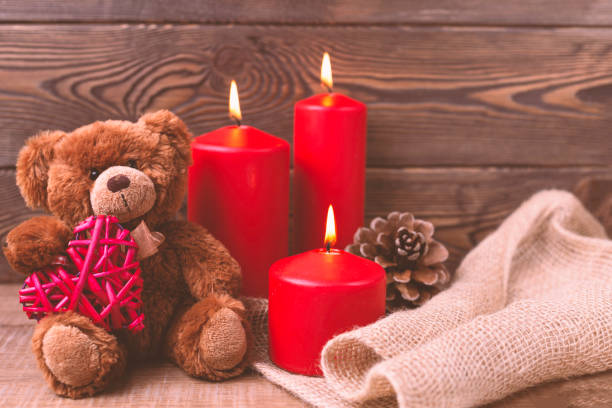 istock Valentine background. Teddy bear keeps the heart, candles and a bump in rustic style . Selective focus. Copy space 1294335177
