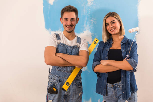istock Confident young couple holding work tools and smiling at camera 1294337396