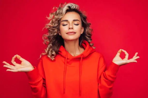 Photo of Beautiful woman wearing red hoodie doing yoga