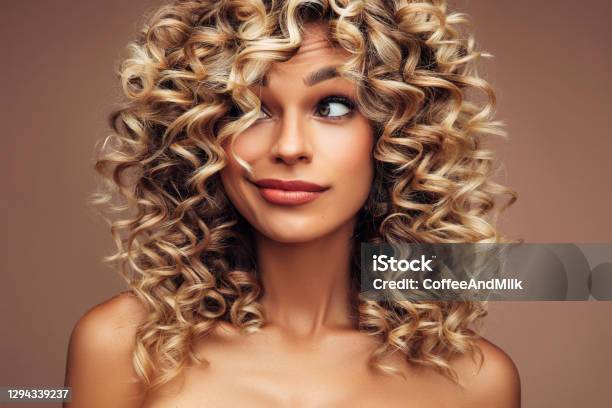 Studio Portrait Of Attractive Young Woman With Voluminous Curly Hairstyle  Stock Photo - Download Image Now - iStock