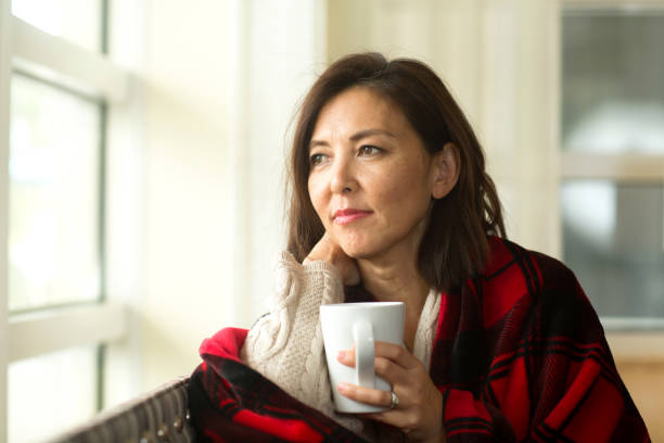 istock Woman sitting on the sofa drinking coffee. 1294339422