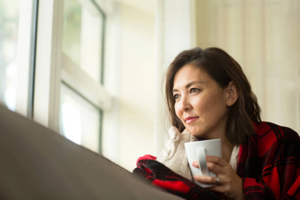 istock Woman sitting on the sofa drinking coffee. 1294339512