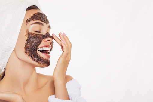 Happy young girl with facial mask on her face