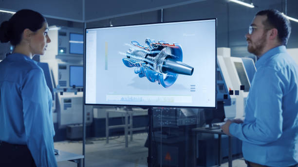 istock Office Meeting: Confident Female Engineer Talks to Project Manager, Watching Interactive Digital Whiteboard TV that Shows New Sustainable Eco-Friendly Engine 3D Concept. Modern Factory with Machinery 1294339681