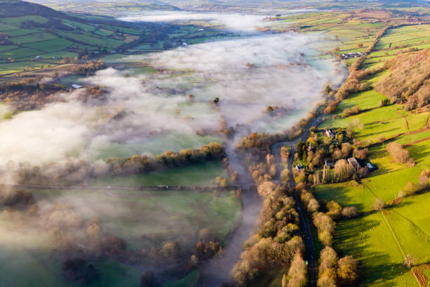 vue aérienne des taches de brouillard le long d’une rivière dans un cadre rural (fleuve usk, pays de galles) - river usk photos et images de collection