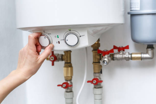 istock Female hand turning on electric water heater (boiler). 1294344005