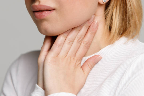 istock woman suffering from throat problems, holding hands on her lymph nodes 1294344867