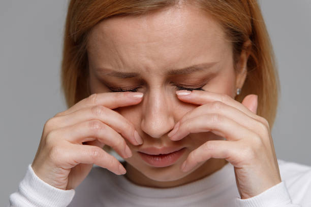 woman has a problem with contact lenses, rubbing her swollen eyes due to pollen