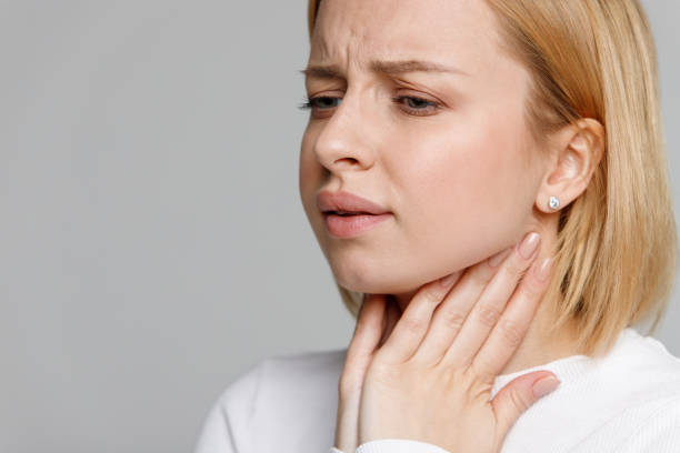 istock woman suffering from throat problems, holding hands on her lymph nodes 1294344875