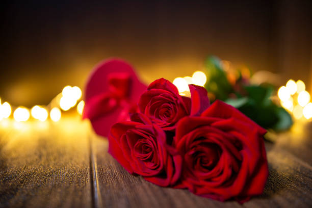 Valentine's Day Gift with Red Roses and envelope on a Dark Wood Background