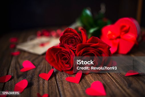 istock Valentine's Day Gift with Red Roses on a Dark Wood Background 1294349315