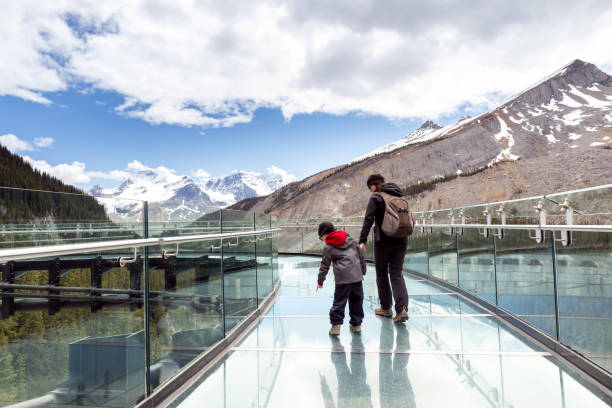 mère et fils se réveillant sur la passerelle de champ de glace de columbia pendant l’été dans le parc national de jasper - jasper alberta photos et images de collection