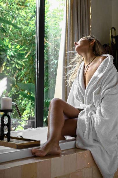 Beautiful woman in a bathtub hotel enjoying the sun and fresh shower in a bathrobe sensuality woman photography close up Portugal hotel photography - fotografia de stock