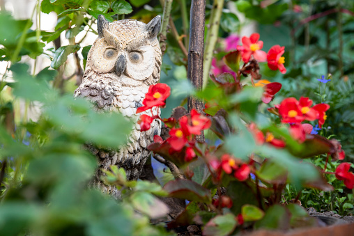 garden sculpture owl in flowers, horizontally