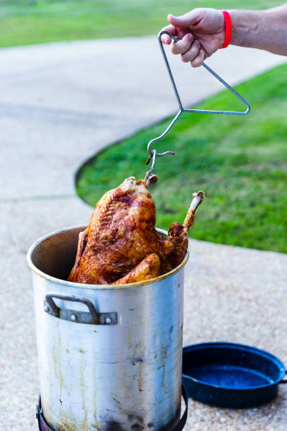 Frying a whole turkey outdoors Frying a whole turkey outdoors for the holiday feast deep fried photos stock pictures, royalty-free photos & images
