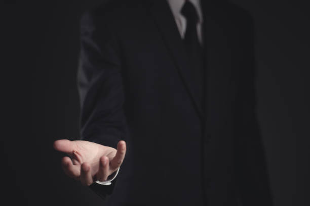 istock Businessman presenting in black suit. 1294372100