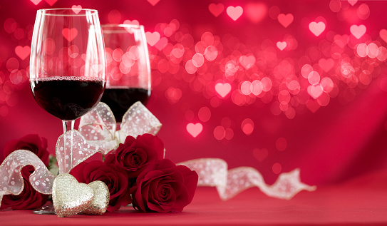 Valentine's Day Red Roses and Red Wine on a Defocused Lights Background