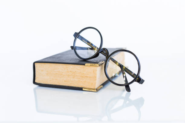 istock Reading glasses on old book on white background 1294374889
