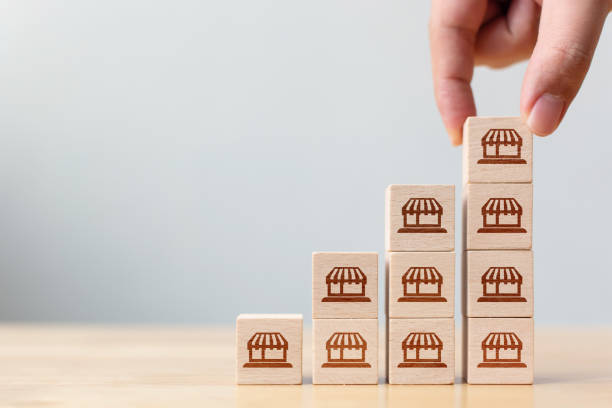 istock Franchise business marketing system concept. Structure service store network strategy. Hand putting wooden block on top with icon store 1294377208