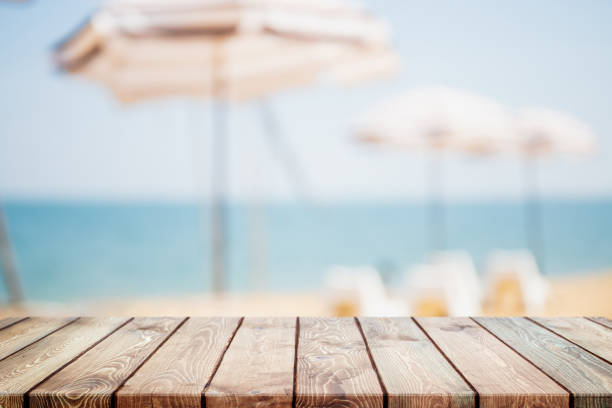 istock Empty wood table top and blurred summer beach in tropical resort banner background - can used for display or montage your products. 1294378096