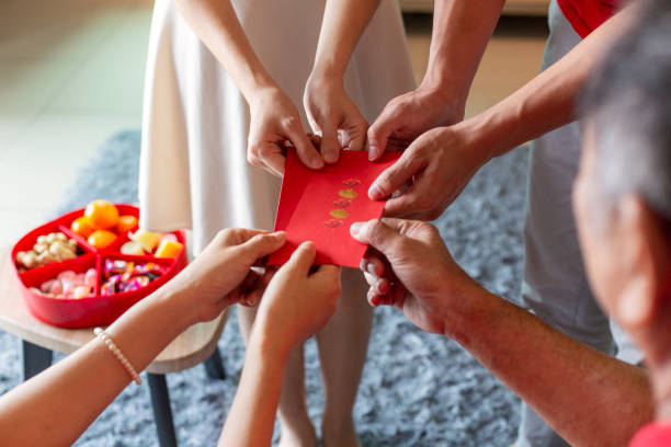 давать красный конверт или hongbao для благословения на китайский новый год - hongbao стоковые фото и изображения