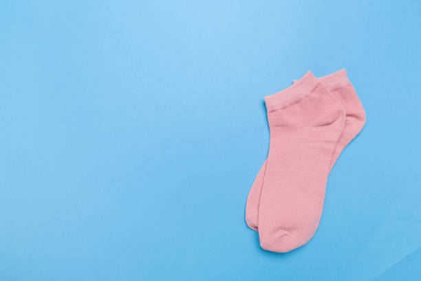 istock pink new socks stacked on a blue background. top view. place for text. 1294380216