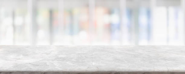 istock Empty white marble stone table top and blur glass window interior cafe and restaurant banner mock up abstract background - can used for display or montage your products. 1294384085