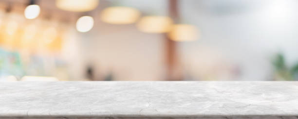 istock Empty white marble stone table top and blur glass window interior cafe and restaurant banner mock up abstract background - can used for display or montage your products. 1294384129