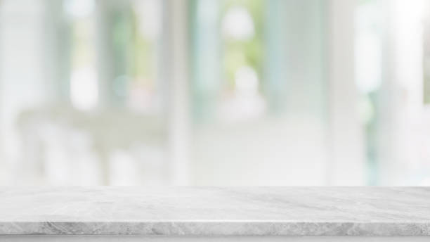 istock Empty white marble stone table top and blur glass window interior cafe and restaurant banner mock up abstract background - can used for display or montage your products. 1294384181