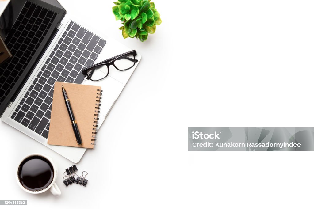 Flat lay, top view office table desk. Flat lay, top view office table desk. Workspace with, laptop,office supplies, pencil, green leaf, and coffee cup on white background. Desk Stock Photo