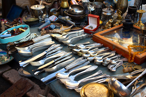 Antiques on flea market or festival, aged vintage silver cultery - spoons, knifes, forks, and other vintage things. Collectibles memorabilia and garage sale concept