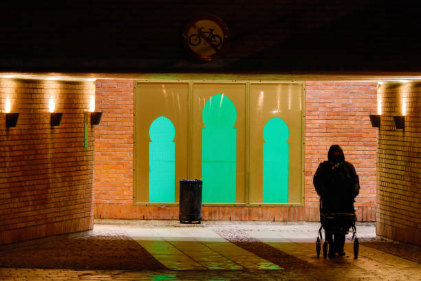 Stockholm, Sweden Sollentuna, Sweden Dec 29, 2020 A pedestrian in an underground passage in the train station of the Sollentuna Centrum suburb and windows shaped like a minaret. sollentuna centrum stock pictures, royalty-free photos & images