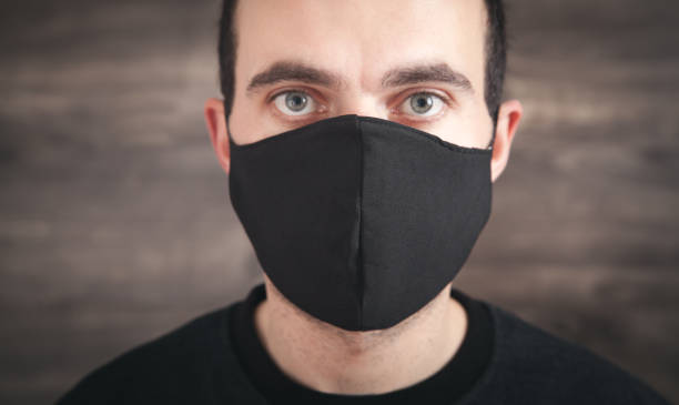 istock Caucasian man wearing black face mask. 1294391521